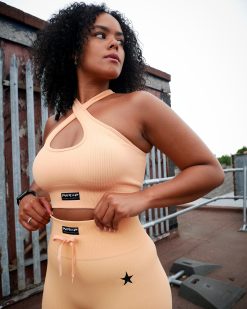 lady wearing poweer x purpose cross bra peach vibe set