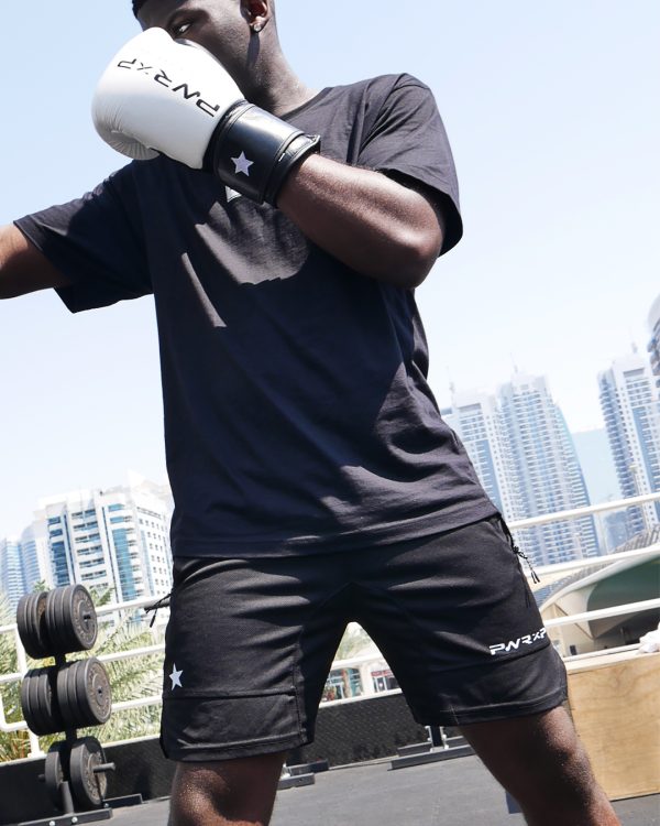 Boxer wearing power x purpose fitted shorts & boxing gloves training at KO8 outdoor gym in Dubai marina.