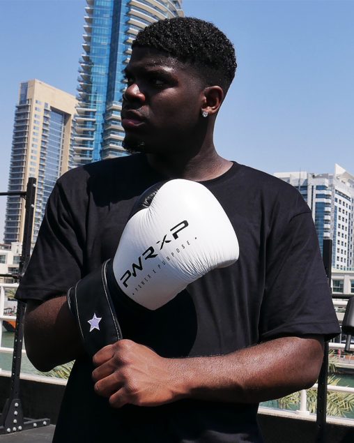 Boxer wearing power x purpose impact boxing gloves training at KO8 outdoor gym in Dubai marina.